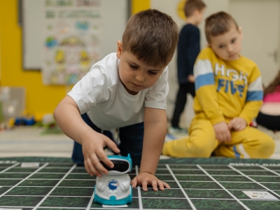 Chłopiec gra z robotem na maty edukacyjnej