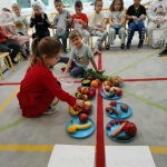Dzieci sortują owoce i warzywa na talerzach w klasie