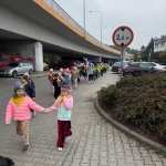 Grupa dzieci idzie pod wiaduktem z oznaczeniem wysokości 2,6 m