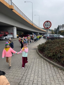 Grupa dzieci idzie pod wiaduktem z oznaczeniem wysokości 2,6 m