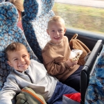 Dwóch uśmiechniętych chłopców siedzi w autobusie