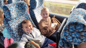 Dwóch uśmiechniętych chłopców siedzi w autobusie