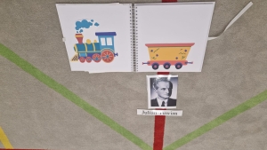 Książka z rysunkami pociągu i wagonu, zdjęcie mężczyzny z napisem "Julian Tuwim"