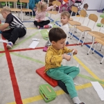 Dzieci siedzą na podłodze w klasie, robiąc ćwiczenia