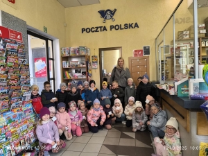 Grupa dzieci i dorosłych w poczcie polskiej