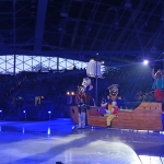 Postacie w kostiumach na lodowisku w hali sportowej