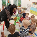 Kobieta pokazuje dzieciom zabawkę żółwia w przedszkolu