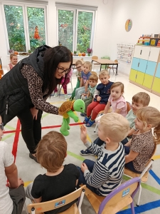 Kobieta pokazuje dzieciom zabawkę żółwia w przedszkolu