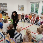 Nauczycielka z zabawką w ręku prowadzi zajęcia z dziećmi