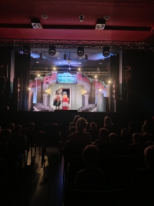 Widownia teatralna z widzami i sceną z dekoracjami