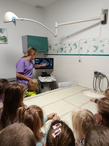 Grupa dzieci obserwuje ultrasonografię wykonywaną przez lekarza