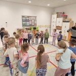 Grupa dzieci i nauczycielka w przedszkolu podczas zajęć