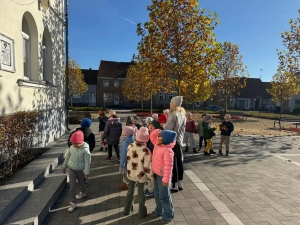 Grupa dzieci z opiekunką na spacerze w parku jesienią