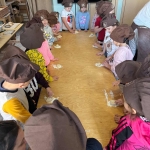 Dzieci w czapkach kuchennych przygotowują ciasto na podłodze