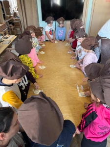 Dzieci w czapkach kuchennych przygotowują ciasto na podłodze