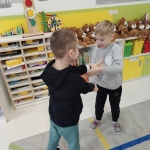 Dwóch chłopców gra w przedszkolu, otoczeni zabawkami i książkami