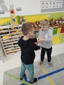 Dwóch chłopców gra w przedszkolu, otoczeni zabawkami i książkami