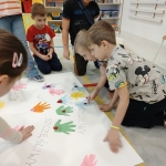 Dzieci w przedszkolu robią ręczne odciski na papierze