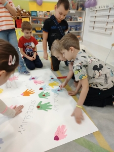 Dzieci w przedszkolu robią ręczne odciski na papierze