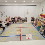 Dzieci siedzą na krzesłach w sali lekcyjnej, ucząc się gry