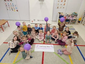 Grupa dzieci w przedszkolu z balonami i zabawkami