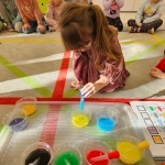 Dzieci bawią się kolorowymi płynami na podłodze