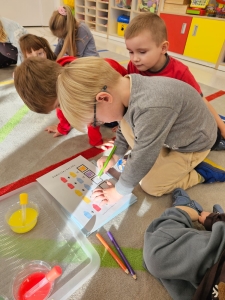 Dzieci w przedszkolu malują obrazki na podłodze