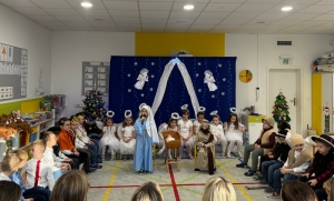 Dzieci w kostiumach występują na scenie w szkolnej sali