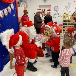 Święty Mikołaj rozdaje prezenty dzieciom w przedszkolu