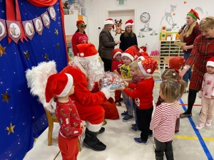 Święty Mikołaj rozdaje prezenty dzieciom w przedszkolu
