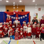 Grupa dzieci i dorosłych w strojach świątecznych przed dekoracją