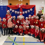 Grupa dzieci i dorosłych w strojach świątecznych przed dekoracją