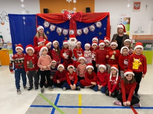 Grupa dzieci i dorosłych w strojach świątecznych przed dekoracją