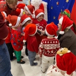 Dzieci w czapkach Mikołaja z Santa Clausem na tle