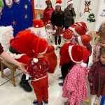 Dzieci w strojach świątecznych spotykają się z Mikołajem