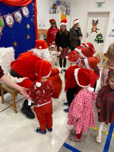 Dzieci w strojach świątecznych spotykają się z Mikołajem