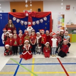 Grupa dzieci w strojach świątecznych z nauczycielami i Mikołajem