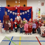 Grupa dzieci i dorosłych w strojach świątecznych przed dekoracją