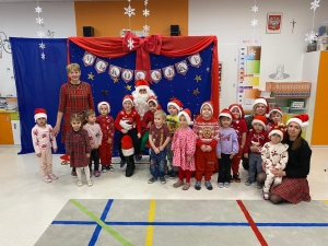 Grupa dzieci i dorosłych w strojach świątecznych przed dekoracją