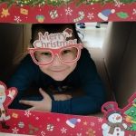 Dziecko w okularach z napisem "Merry Christmas" w ramce świątecznej