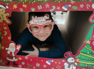 Dziecko w okularach z napisem "Merry Christmas" w ramce świątecznej