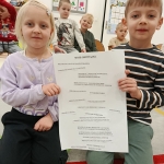 Dwoje dzieci trzymają listę obowiązków w przedszkolu