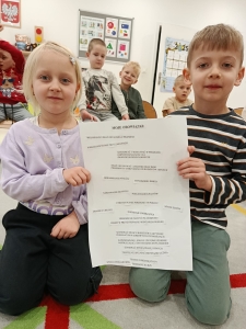 Dwoje dzieci trzymają listę obowiązków w przedszkolu