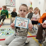 Dziecko trzyma kartkę z napisem "Prawo do dostępu do informacji"