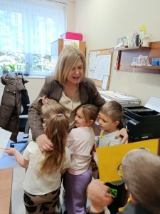 Kobieta uśmiecha się do dzieci w przedszkolu