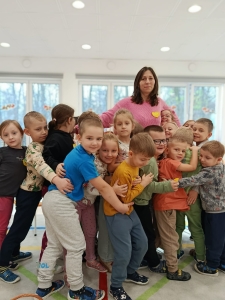 Grupa dzieci z nauczycielką w szkolnej sali