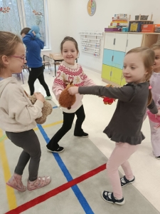 Dzieci w przedszkolu grają z pluszakami w pomieszczeniu