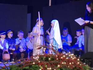 Dzieci w strojach występują na scenie podczas przedstawienia