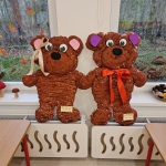 Dwa duże misie z ciasteczek stoją na podstawkach przy oknie