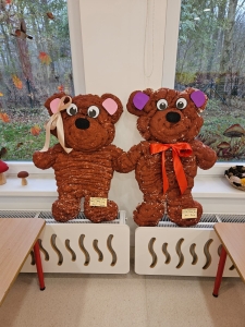 Dwa duże misie z ciasteczek stoją na podstawkach przy oknie